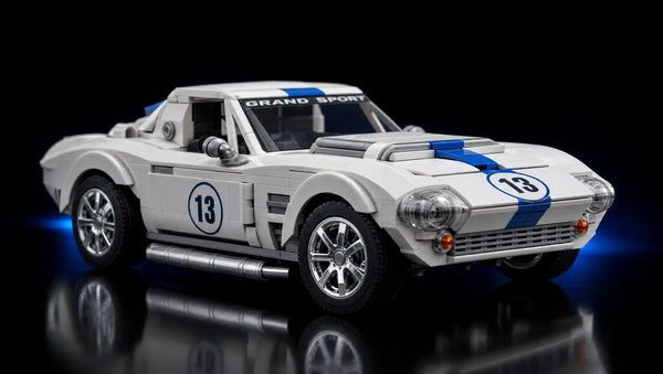 Weißer Mattel Brick Shop JGR31 Chevrolet Corvette Grand Sport mit blauem Rallyestreifen silbernen Felgen und silbernen Auspuff Frontalansicht von vorne links